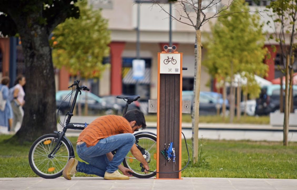 Ciclista a encher pneu de bicicleta na bike station Plaza da Floema Urban, equipamento para a mobilidade suave urbana.